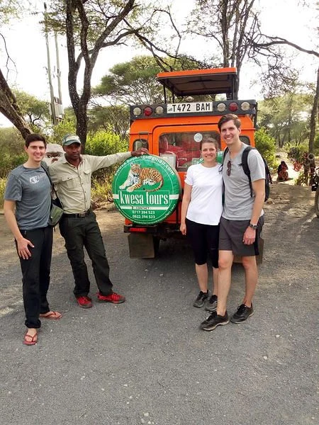 Kwesa’s team and guests beside a safari vehicle